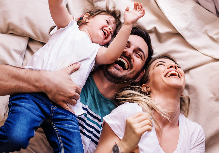 Family smiling on the bed
